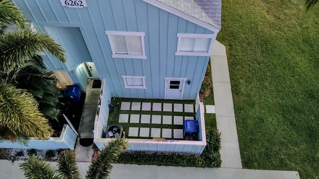 a view of house with a yard and potted plants