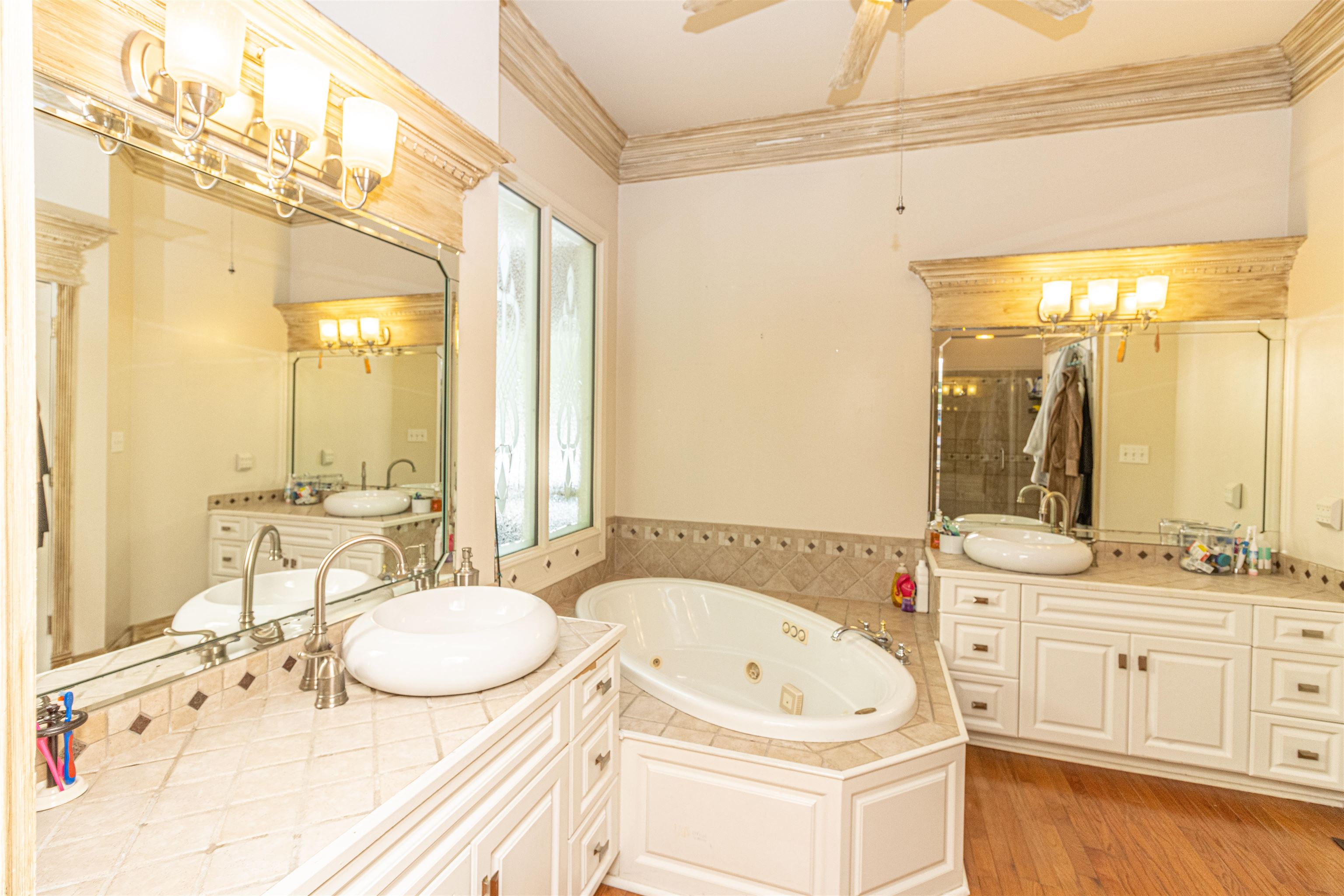 3501 Blue Bird Lane Corinth, MS 38834 - Photo 14 of 25 a bathroom with a tub a sink and a large mirror