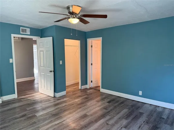 a view of an empty room with window and wooden floor