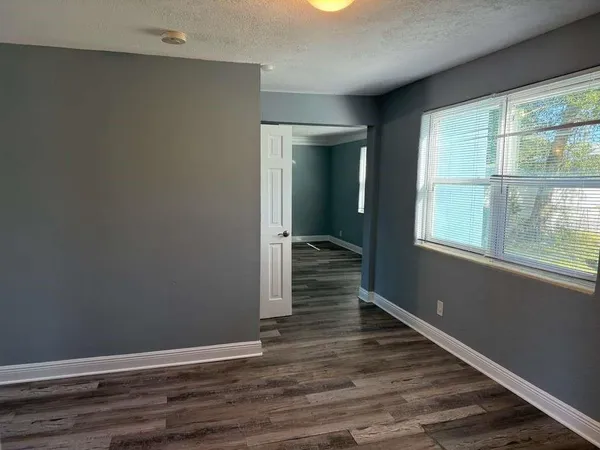 a view of a hallway with wooden floor and a window