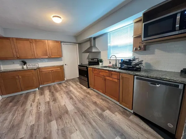 a kitchen with stainless steel appliances granite countertop a sink a stove and a microwave