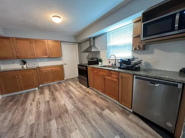 a kitchen with stainless steel appliances granite countertop a sink a stove and a microwave