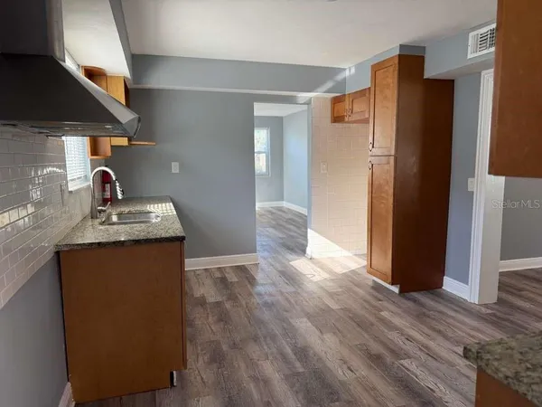 a kitchen with granite countertop a refrigerator and a sink