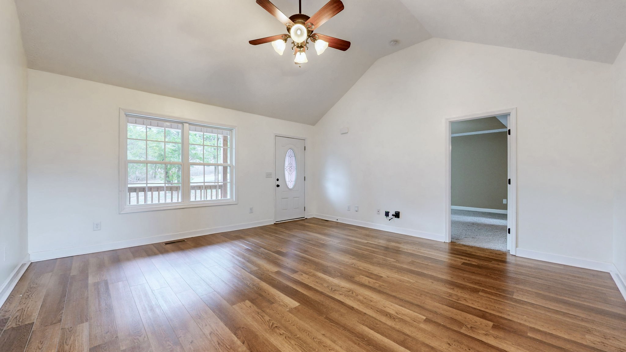 574 Keytown Road Portland, TN 37148 - Photo 11 of 45 an empty room with wooden floor chandelier fan and windows