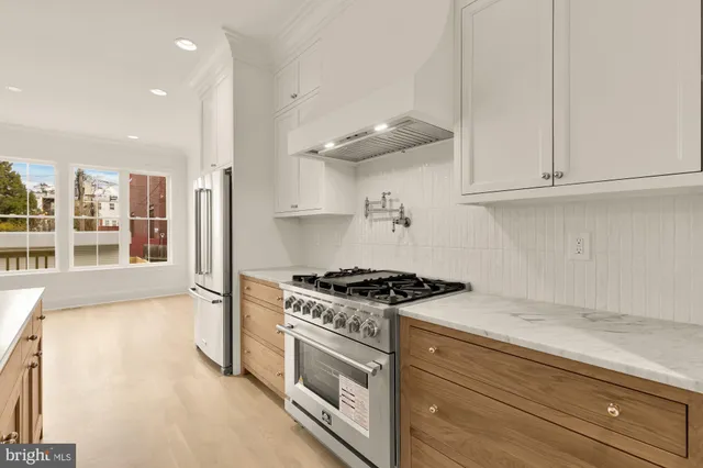 a kitchen with stainless steel appliances granite countertop a stove and a white cabinets