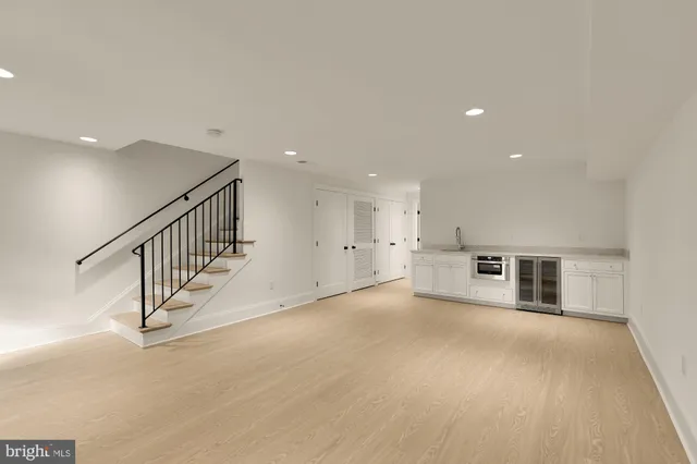 an empty room with staircase and white walls
