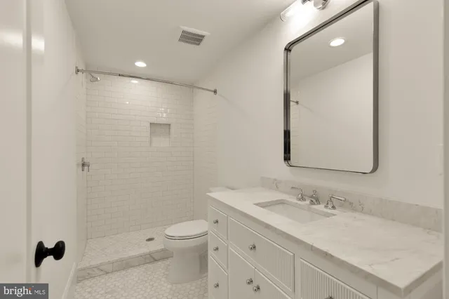a bathroom with a sink toilet vanity and shower