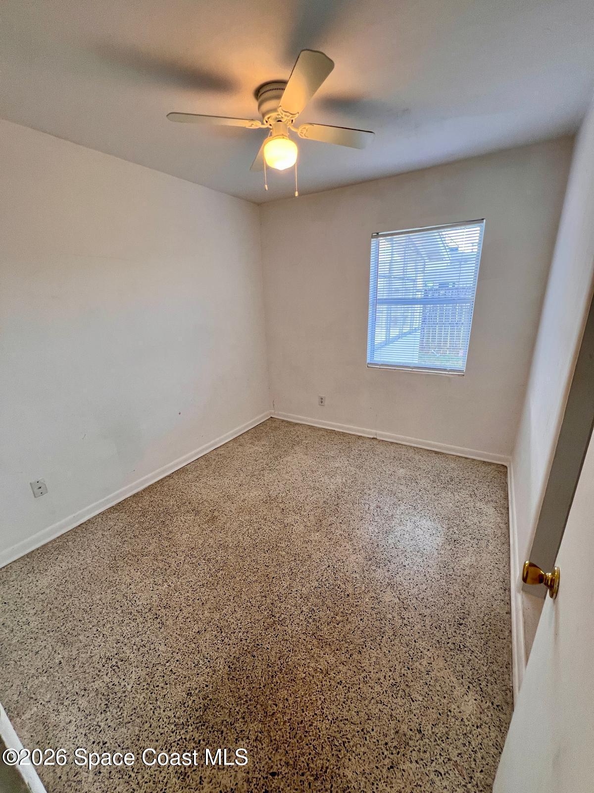 1040 Croton Road Melbourne, FL 32935 - Photo 7 of 10 an empty room with a fan & a window