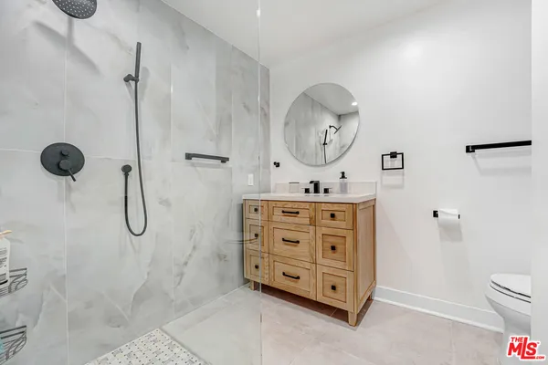 a bathroom with a granite countertop sink a toilet and a mirror