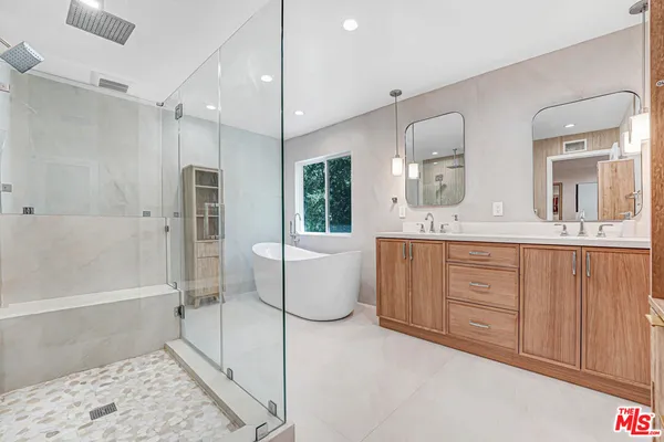 a bathroom with a double vanity sink toilet mirror and bathtub