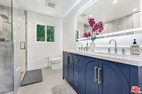 a bathroom with a sink vanity mirror and toilet
