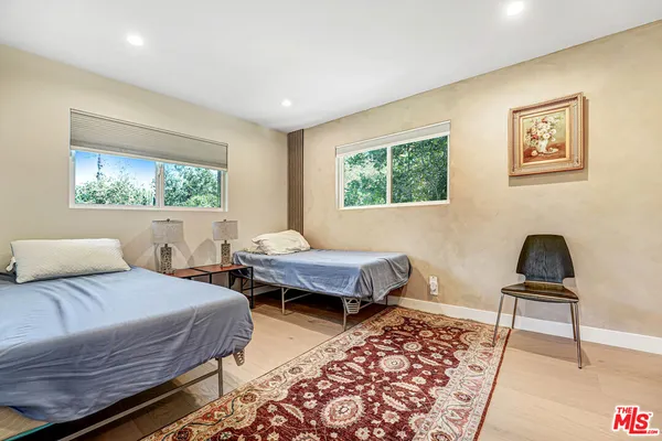 a bedroom with 2 bed and a window