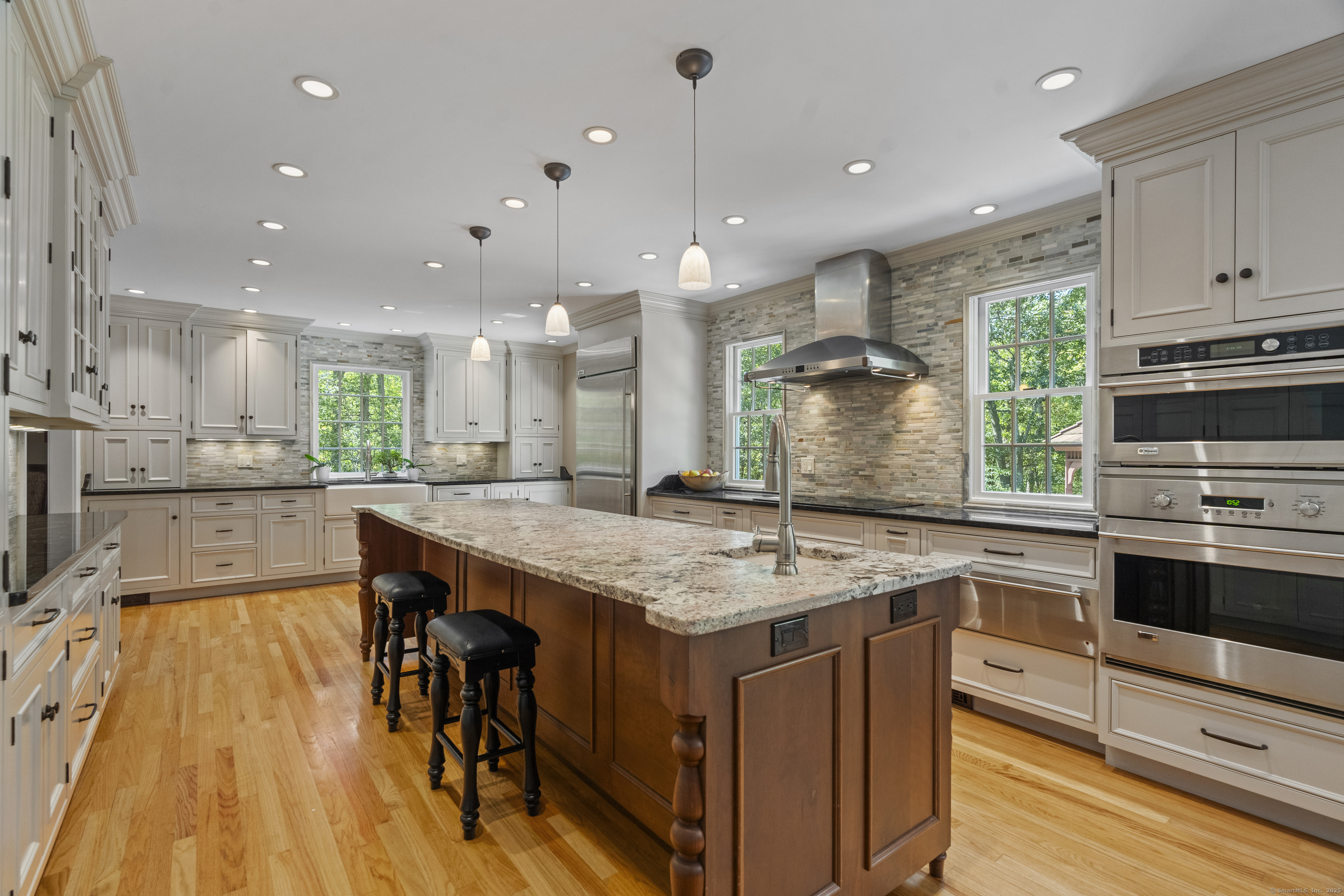a kitchen with kitchen island a stove a sink a center island and cabinets