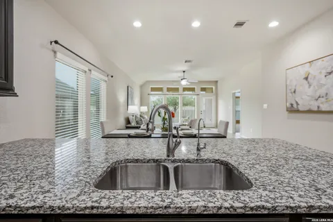 a view of kitchen sink a faucet cabinets and stainless steel appliances