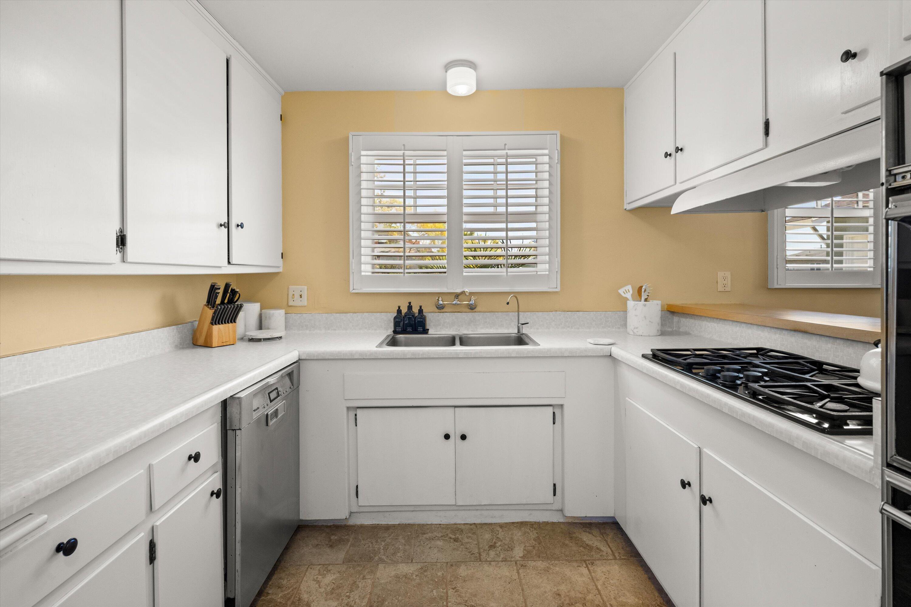 231 Salida Del Sol Santa Barbara, CA 93109 - Photo 11 of 30 a kitchen with granite countertop white cabinets and white appliances