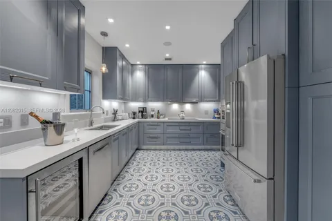 a large kitchen with a sink and refrigerator
