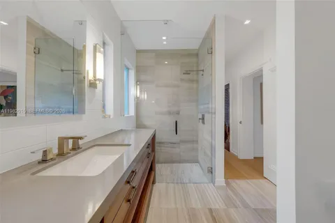a bathroom with a sink a toilet a glass door shower and mirror