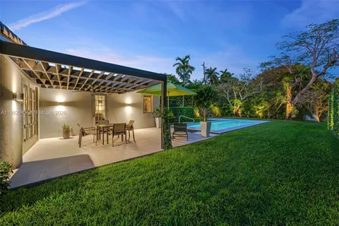 a view of a chairs and table in patio with a yard