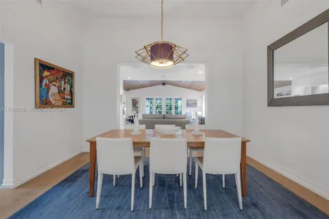 a dining room with wooden floor a glass table and chairs