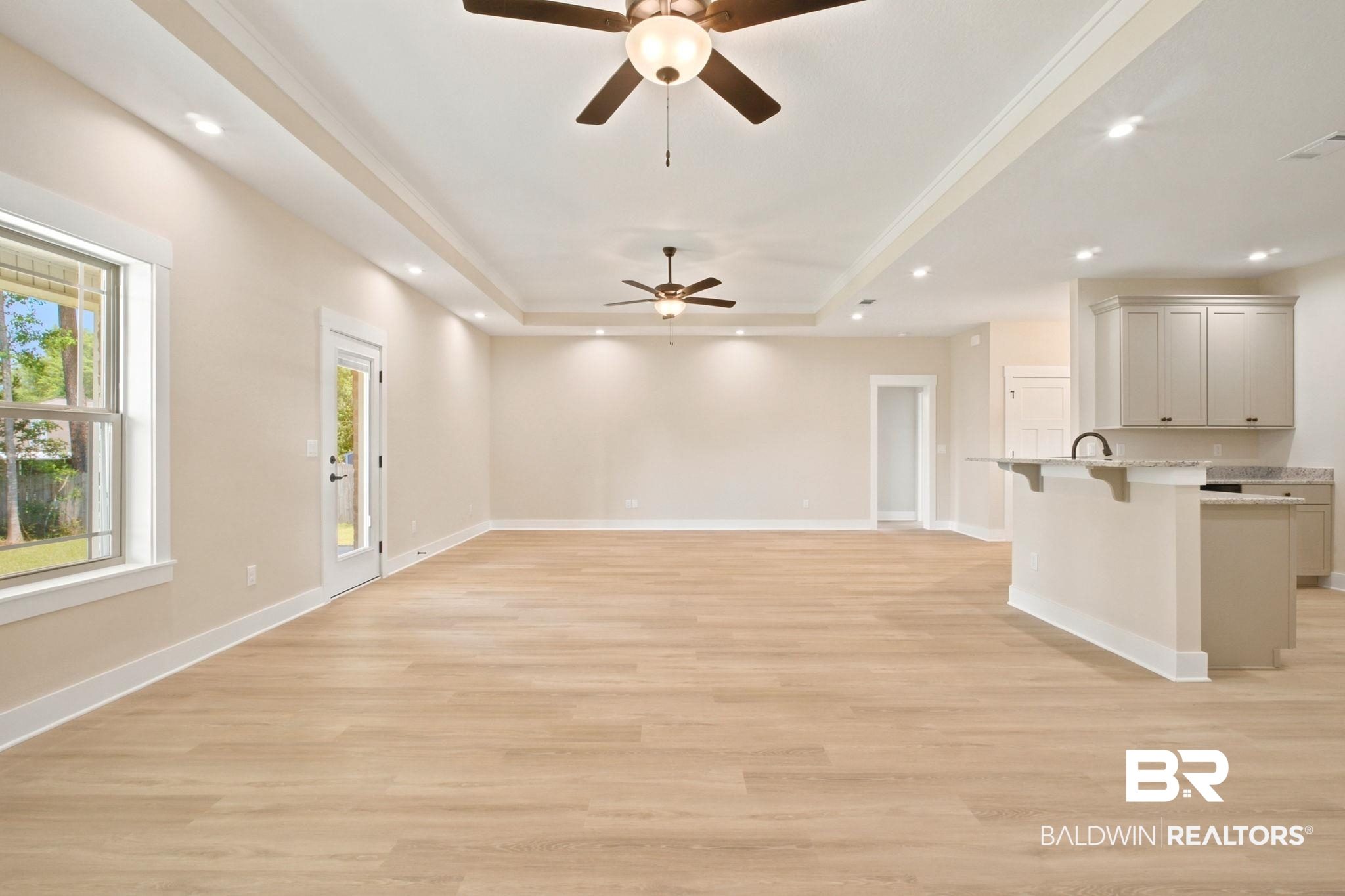 32656 Arbor Ridge Circle Lillian, AL 36549 - Photo 6 of 56 Spacious open-concept room featuring light wood-finish flooring, recessed lighting, and a tray ceiling with two ceiling fans