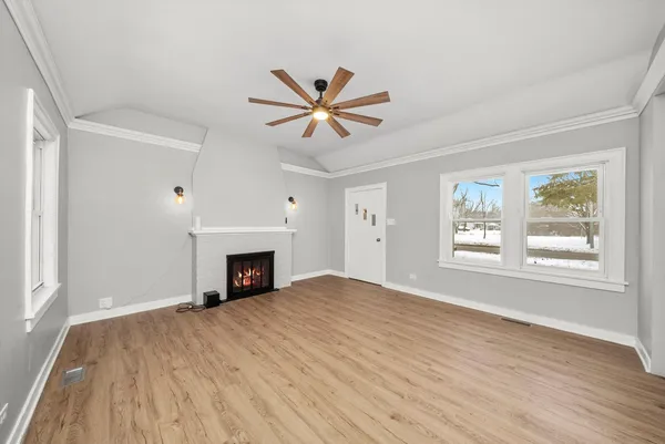 an empty room with windows and fireplace