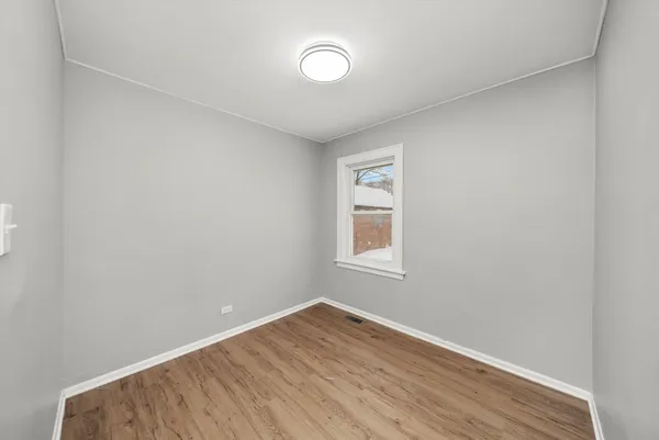 an empty room with a window and closet area