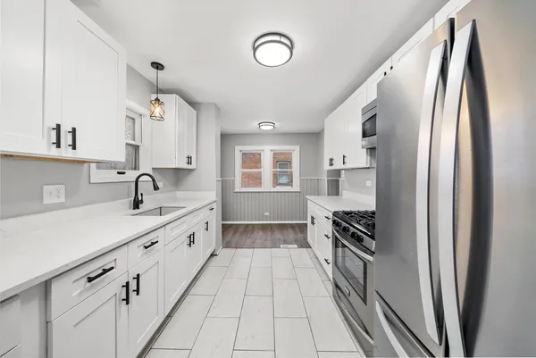 a kitchen with granite countertop a refrigerator and a sink
