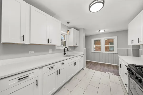 a kitchen with granite countertop white cabinets and white appliances