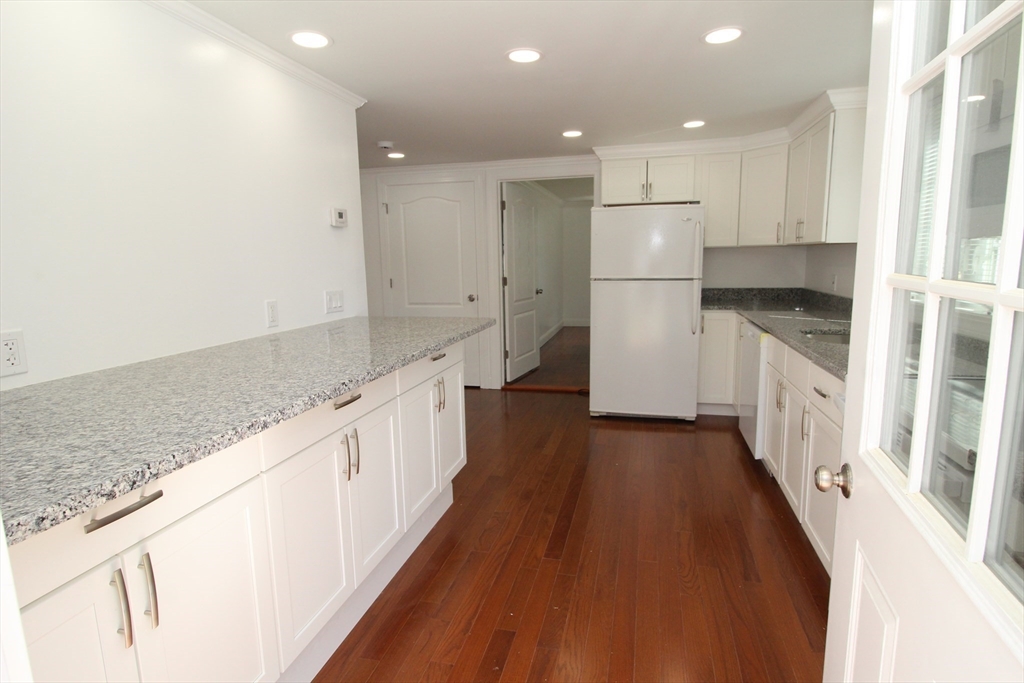 96 Walnut Lane, Unit B Attleboro, MA 02703 - Photo 9 of 20 a kitchen with granite countertop a sink and a refrigerator