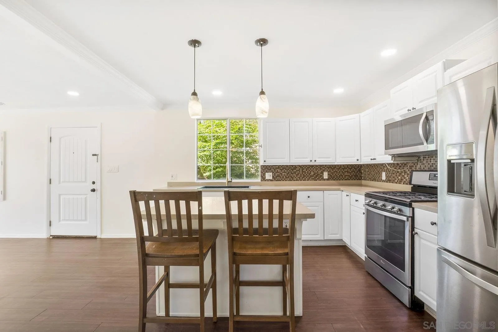 8545 Gardena Road Lakeside, CA 92040 - Photo 26 of 67 a kitchen with a table chairs microwave and cabinets
