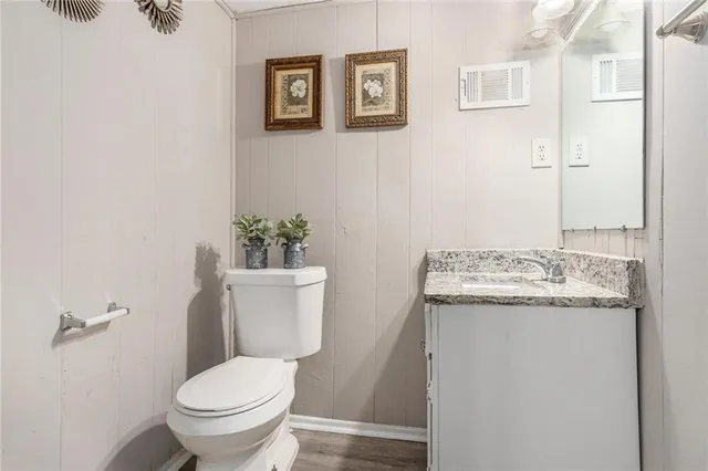 a bathroom with a granite countertop toilet and a sink
