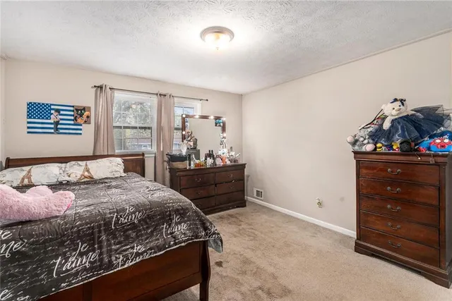 a bedroom with a bed and a dresser in it