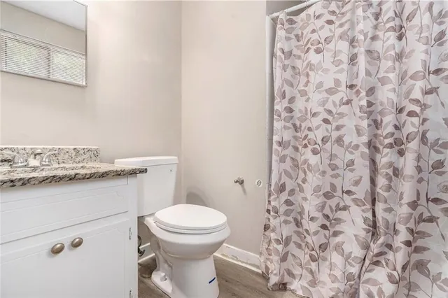 a bathroom with a granite countertop toilet and a sink