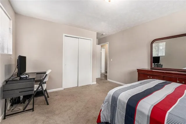 a bedroom with a bed and a computer on a desk