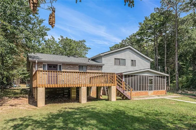 a view of a house with a yard and a wooden deck
