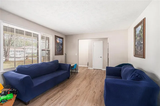 a living room with a couch wooden floor and a large window