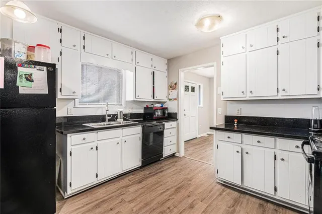 a kitchen with granite countertop a sink cabinets and stainless steel appliances