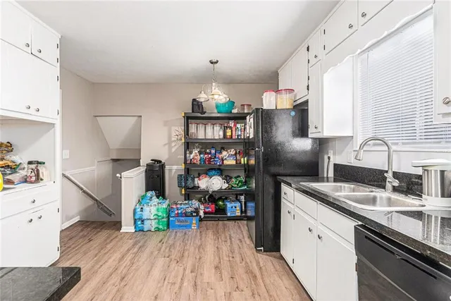 a kitchen with stainless steel appliances granite countertop a refrigerator sink and wooden floor