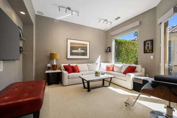a view of a patio with couches table and chairs with plants and large trees