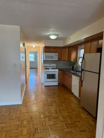 a kitchen with granite countertop a refrigerator and a stove top oven