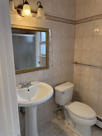 a bathroom with a toilet sink and mirror