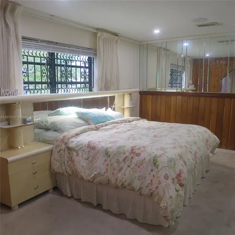 a large bed sitting in a room next to a window