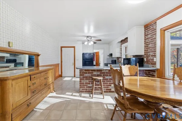 a living room with furniture a flat screen tv and kitchen view