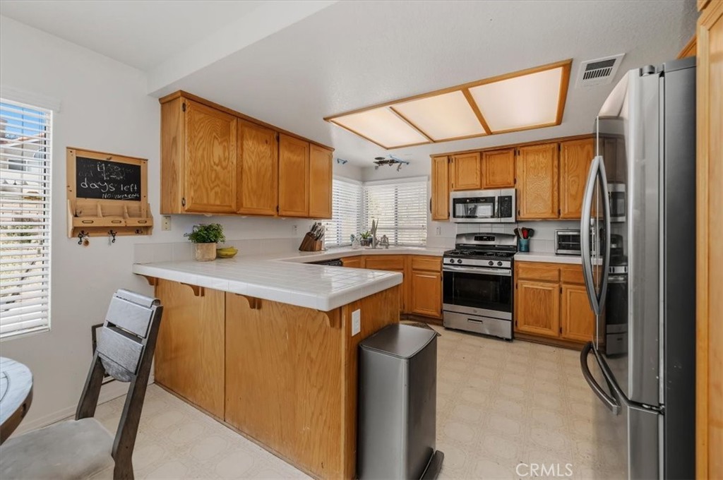 352 Leafwood Court Riverside, CA 92506 - Photo 14 of 42 a kitchen with stainless steel appliances a stove refrigerator sink and a microwave