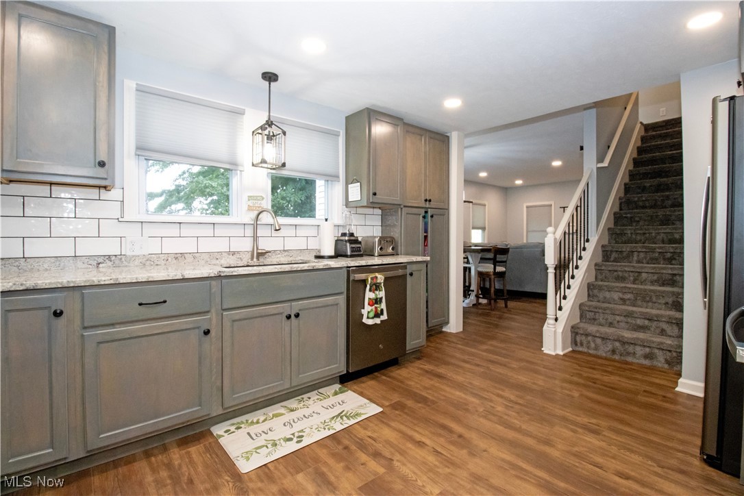 8984 Spencer Road Homerville, OH 44235 - Photo 18 of 27 Kitchen with appliances with stainless steel finishes, dark hardwood / wood-style flooring, and backsplash