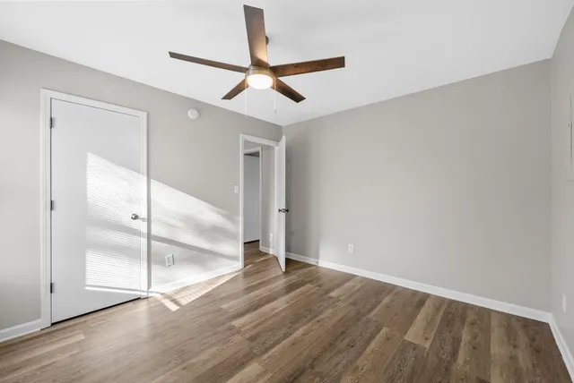a view of empty room with wooden floor