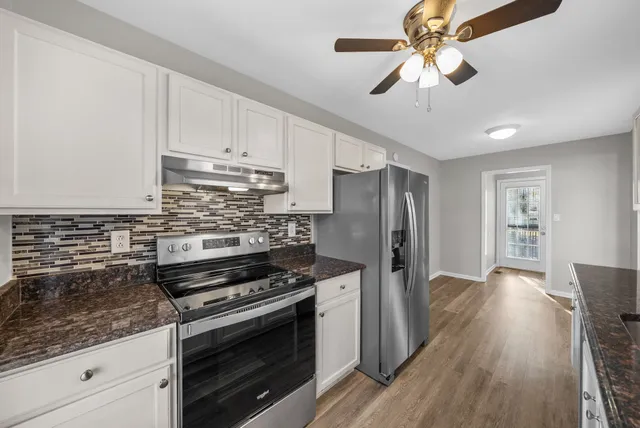 a kitchen with stainless steel appliances granite countertop a stove a refrigerator and a microwave