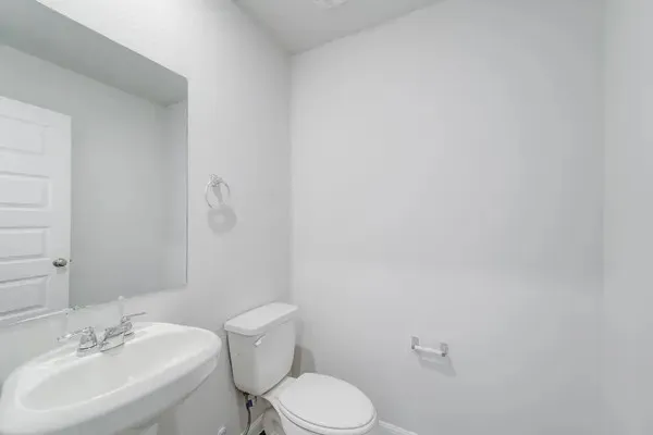 a bathroom with a toilet a sink and mirror
