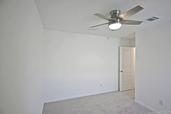 an empty room with a window and a fan