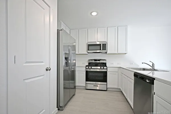 a kitchen with kitchen island a sink stainless steel appliances and cabinets